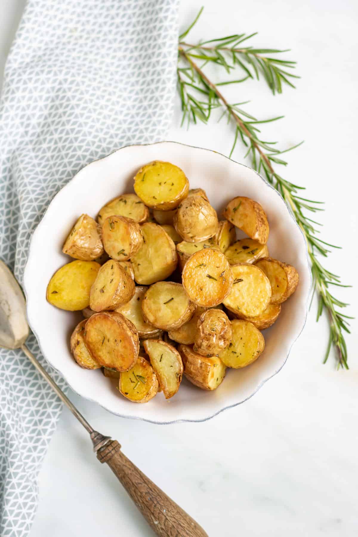A table with a bowl of roasted baby potatoes.