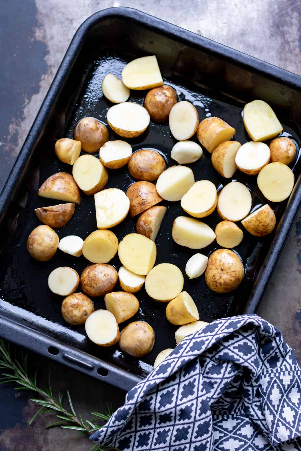 Baby potatoes on a pan ready to be cooked.
