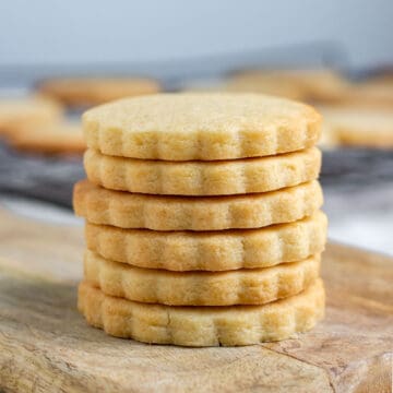 A stack of cookies on a wooden board.
