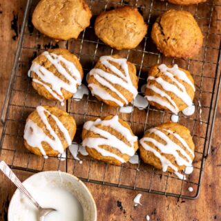 Cookies on a rack, and a bowl of icing.