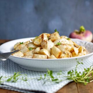 A serving dish piled with roasted turnips.