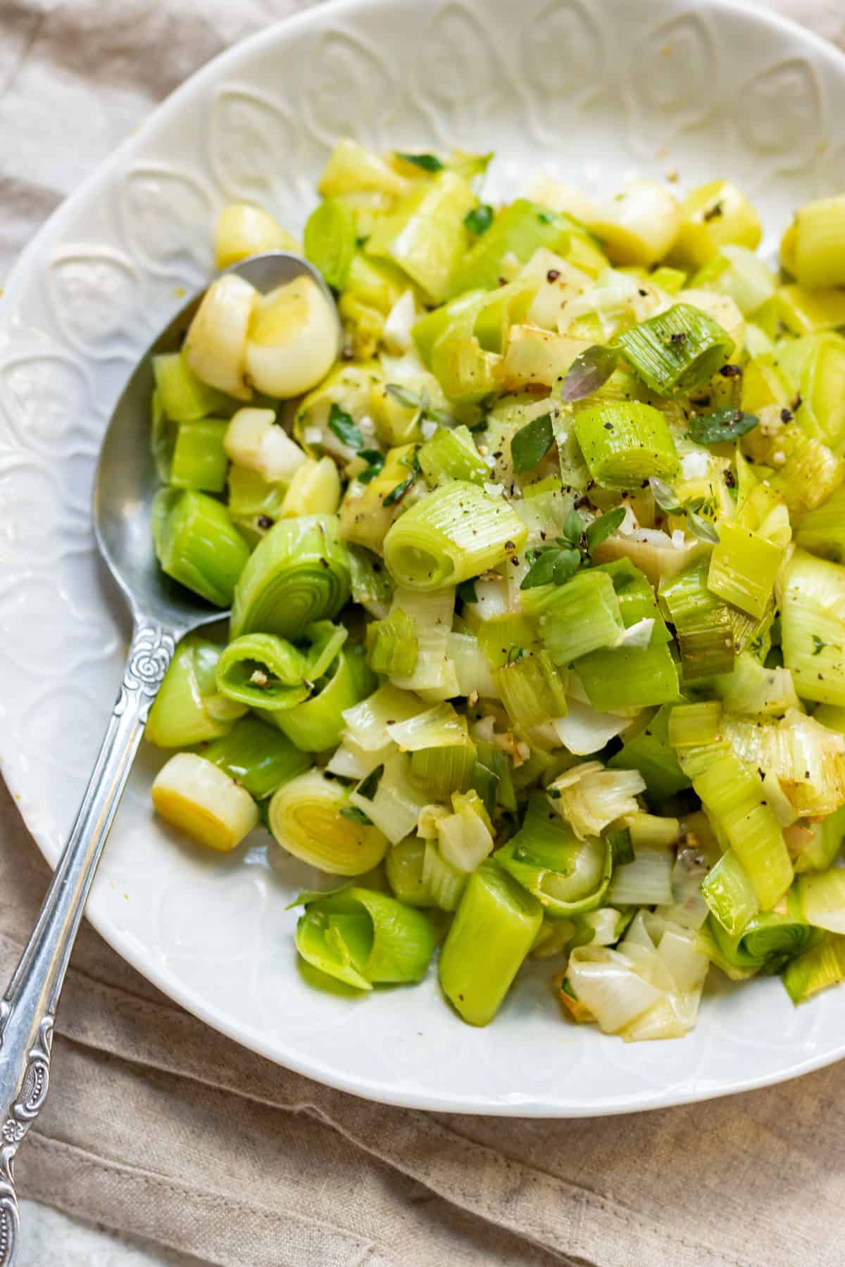 Spoon in a dish of sautéed buttered leeks.