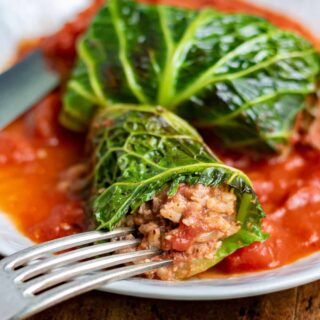 Close up of a cut open vegan cabbage roll on a plate.