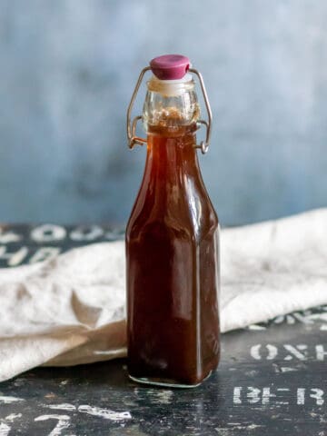 Bottle of chai simple syrup on a wooden table.