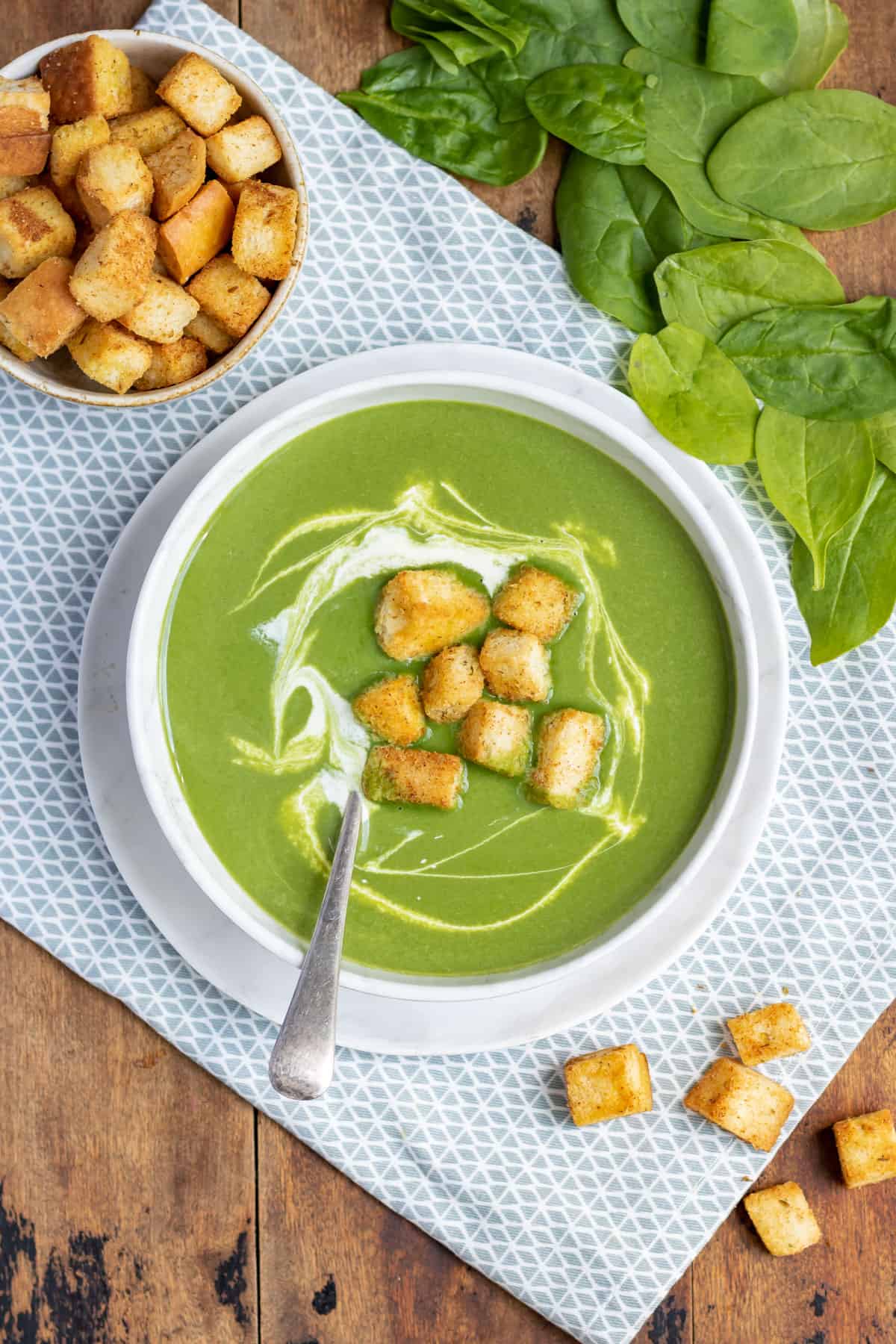 Table with a bowl of soup topped with croutons.