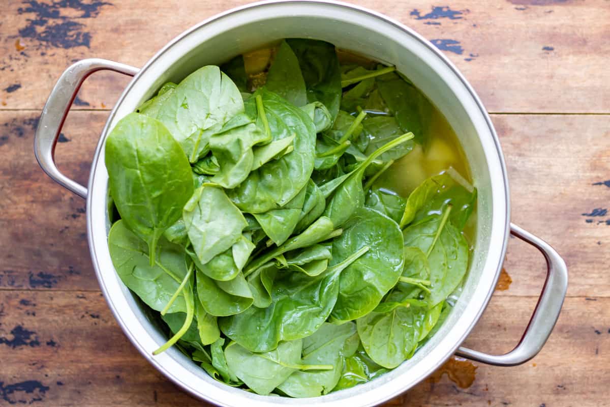 Spinach and other ingredients added to the pot.