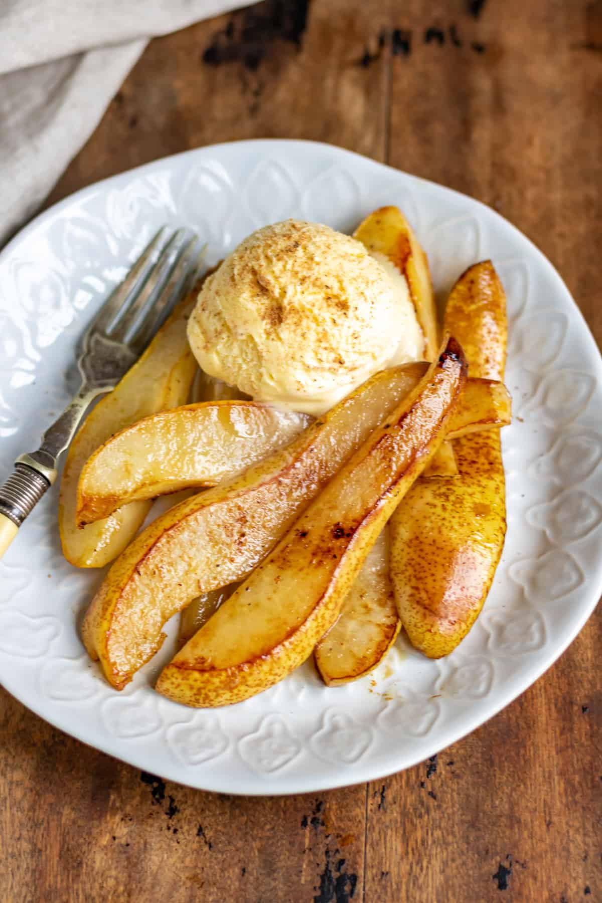 Close up of fried pears and ice cream on a plate.
