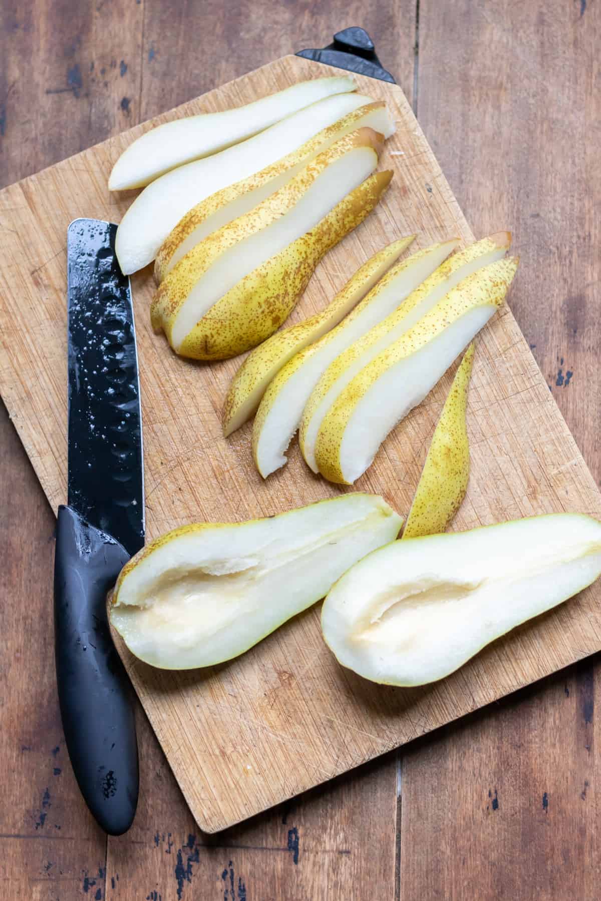Slicing a pear on a cutting board.