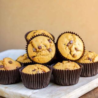 A pile of sweet potato muffins on a wooden board.