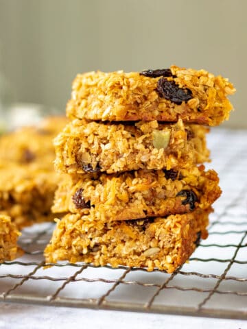 A stack of carrot flapjacks on a wire rack.