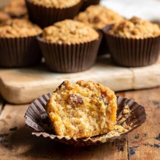Carrot Muffin with a bite out on a table.