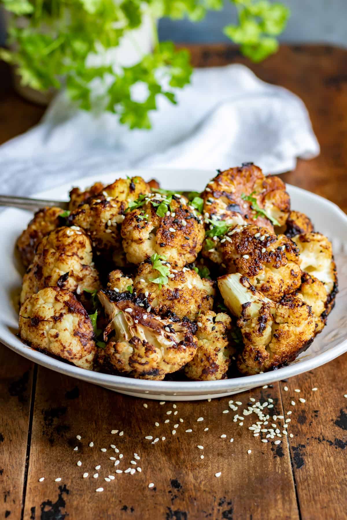 A table with a serving dish of miso cauliflower.