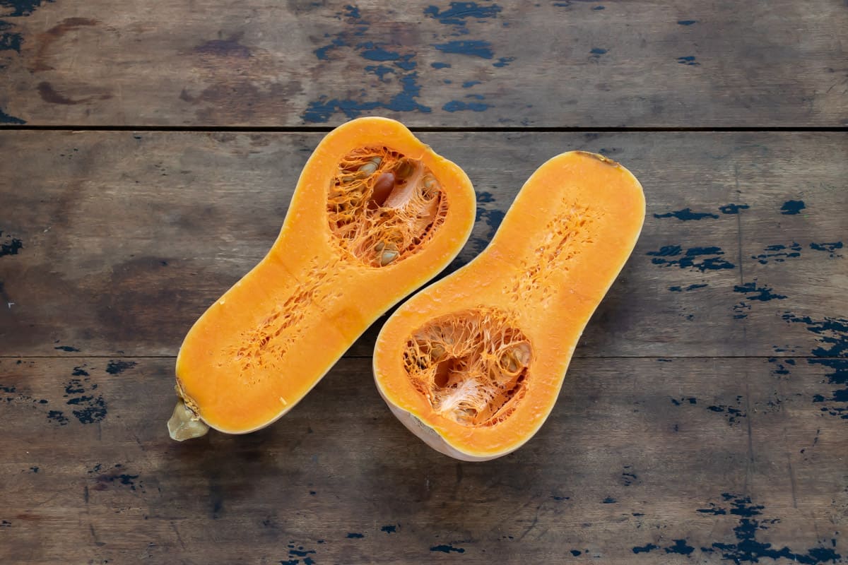 Cut open butternut squash on a wooden table.