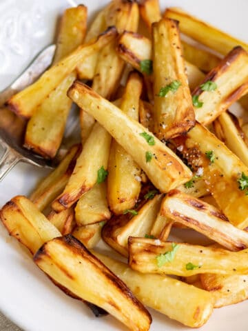 A serving dish of air fryer honey roasted parsnips.