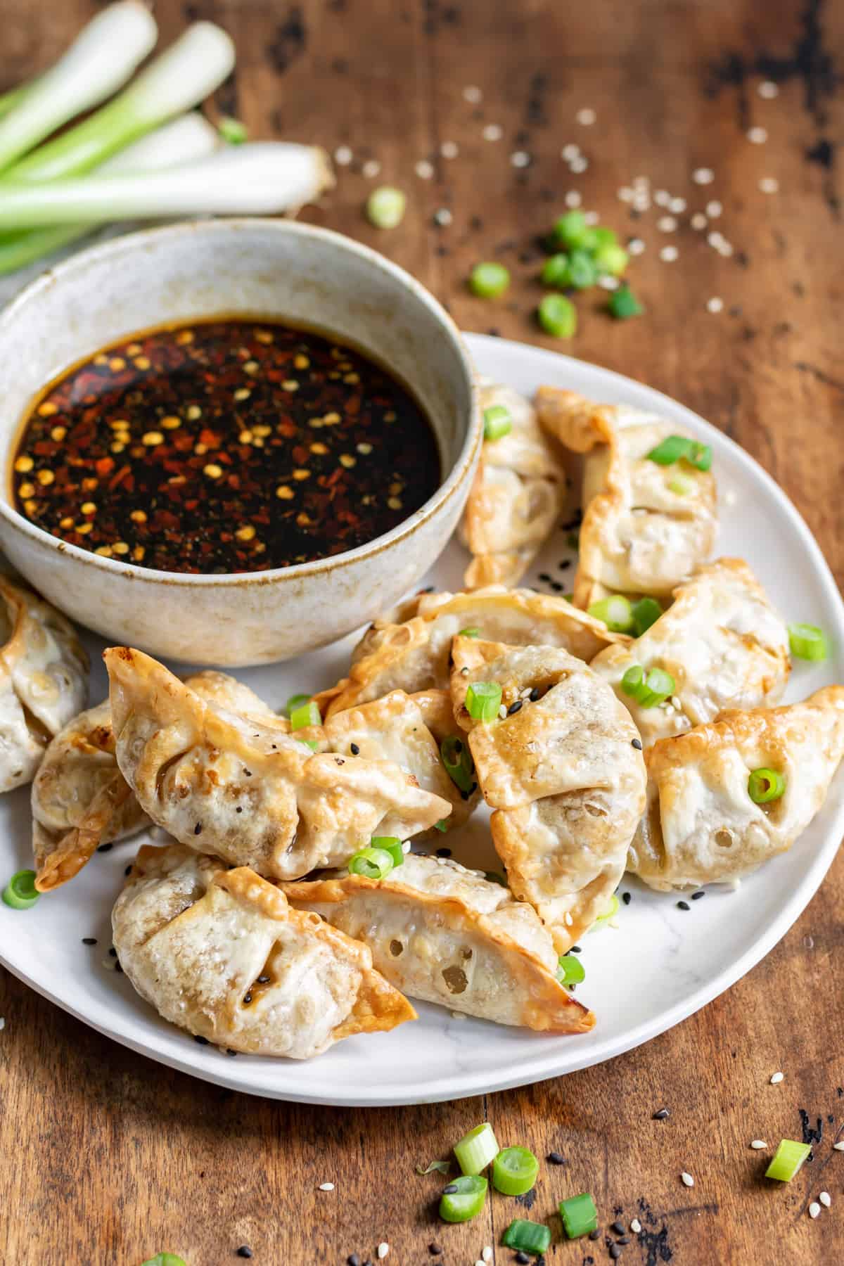 Plate of air fried potstickers and dipping sauce.