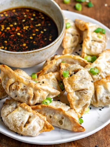 Plate of air fried potstickers and dipping sauce.