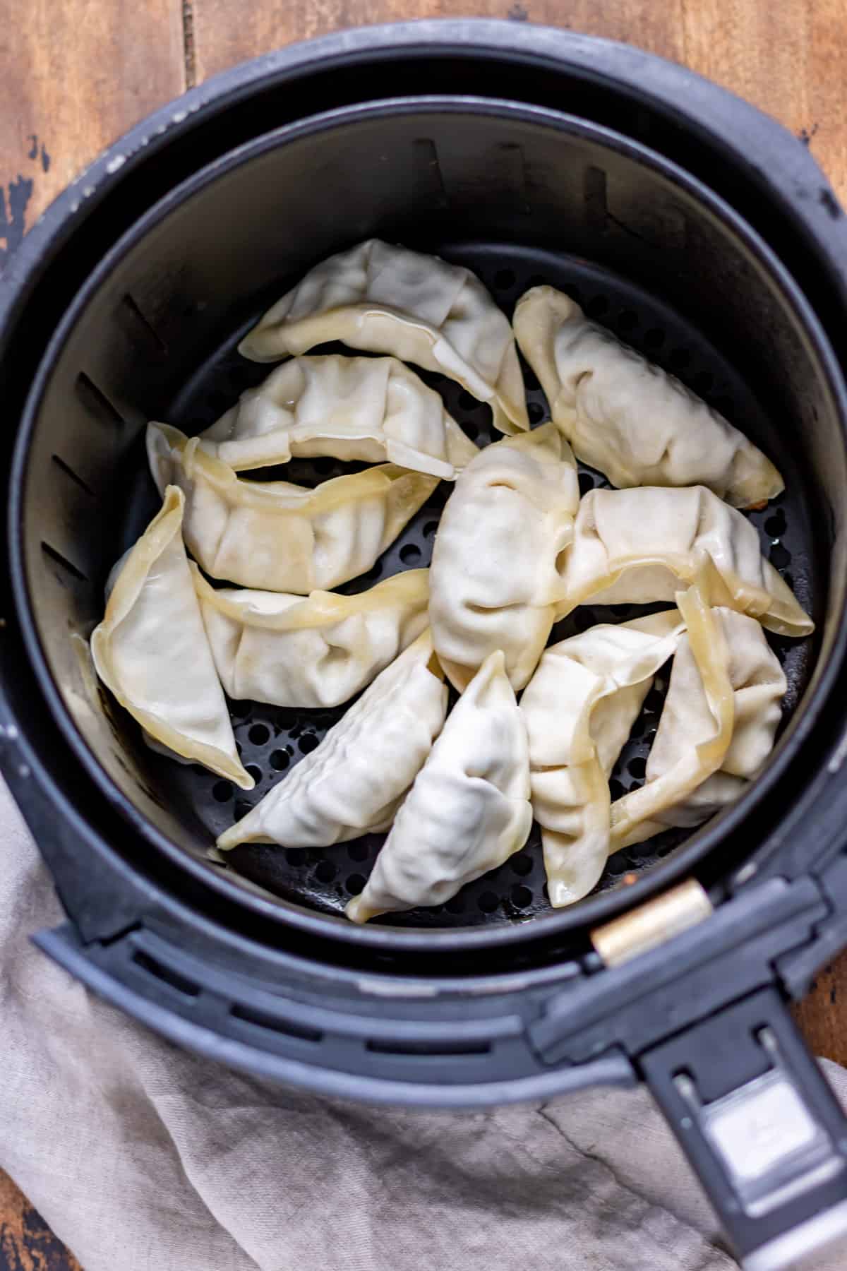 Potstickers added to the basket of the air fryer.