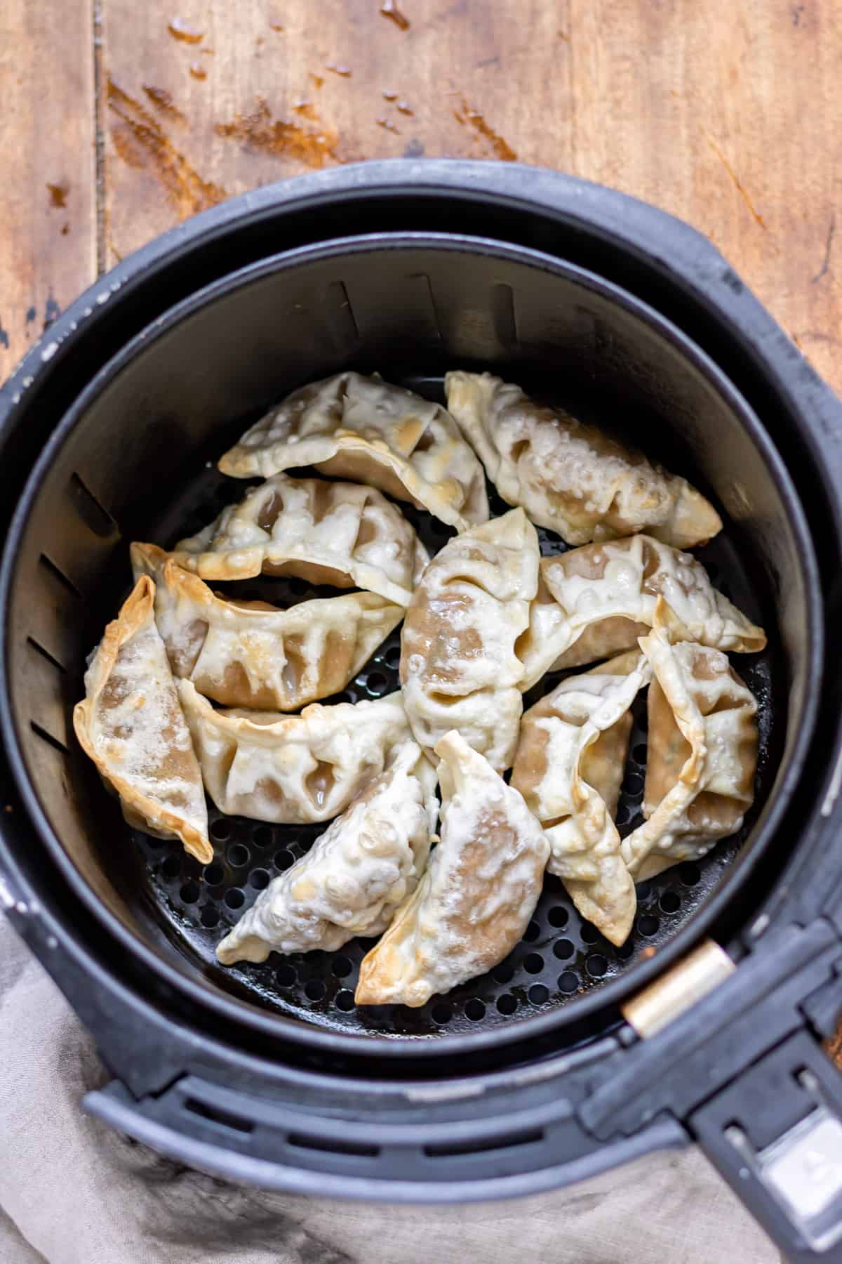 Partially cooked potstickers in air fryer.
