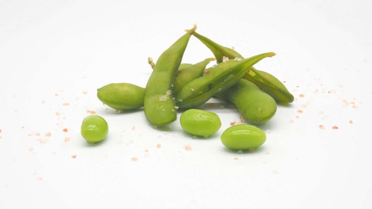 A pile of shelled and unshelled cooked edamame beans.