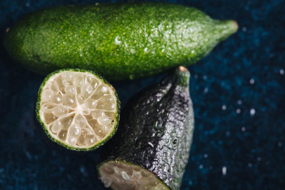 Fingerlimes on a table with one cut open.