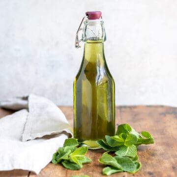 Bottle of mint simple syrup on a table.