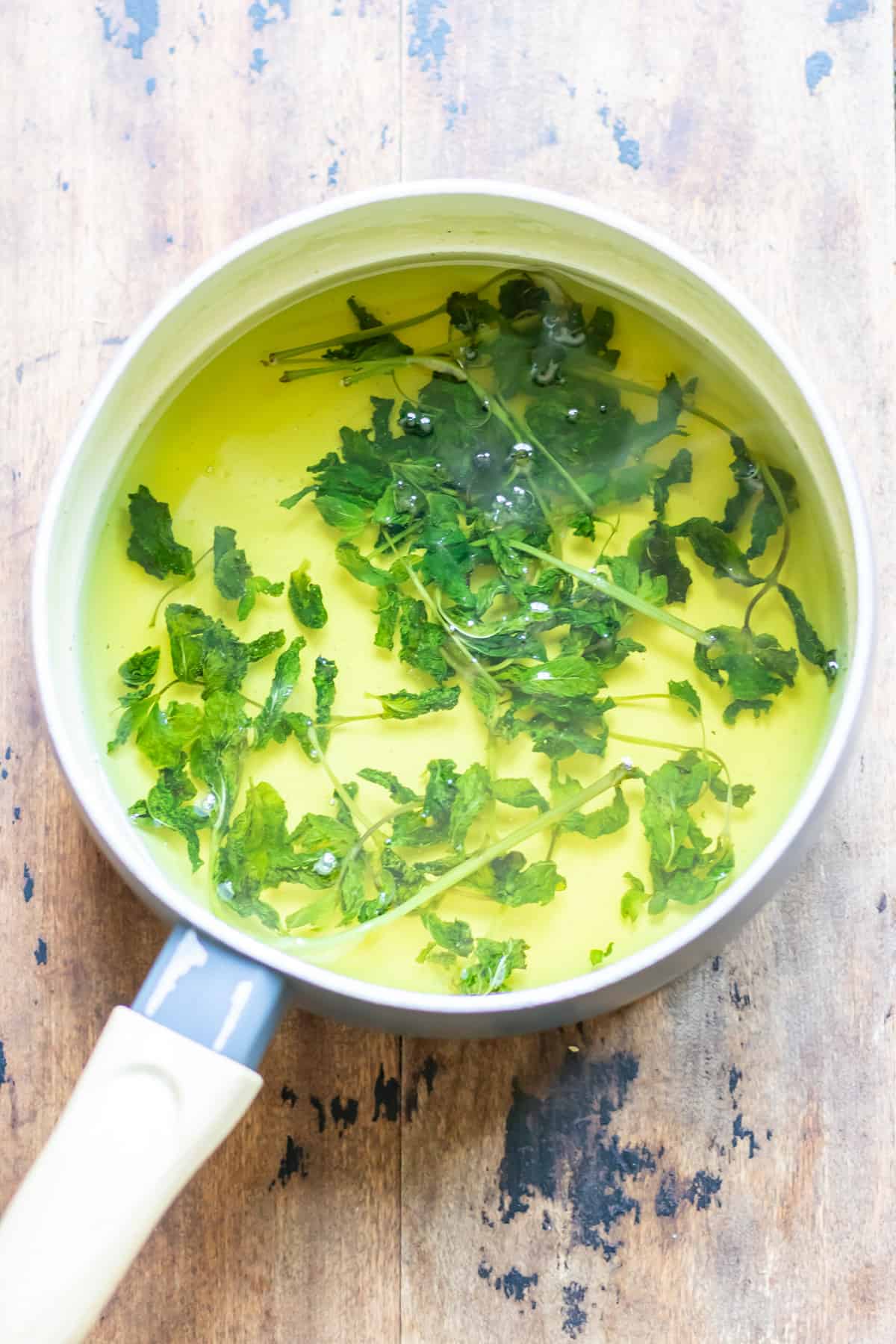 Syrup in a pan with mint leaves.