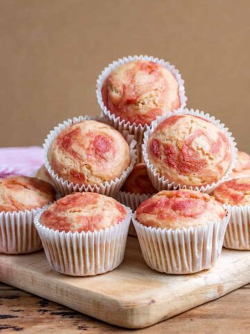A table with a pile of rhubarb muffins.