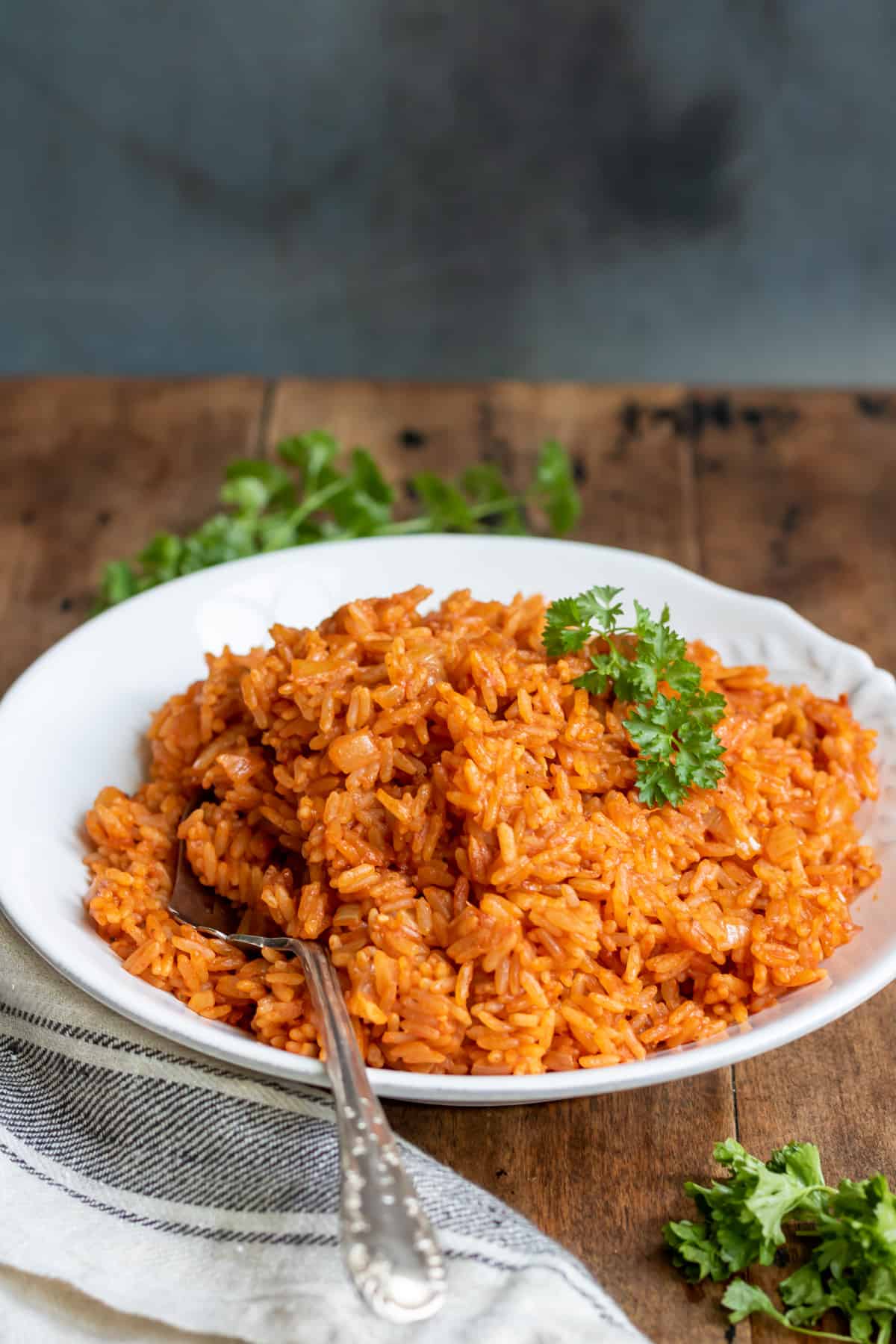 A spoon in a dish of rice on a table.