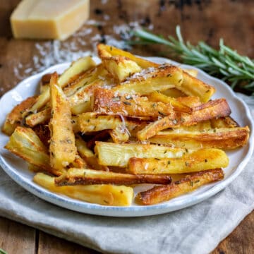 Close up of a plate of roasted parmesan parsnips.
