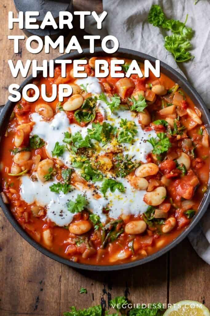 Soup in a bowl on a table, with text: Hearty Tomato White Bean Soup.