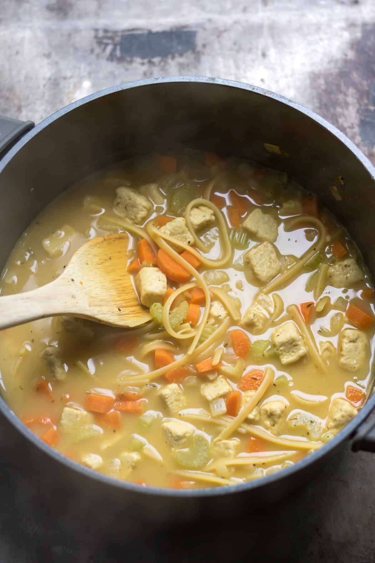 Vegan noodle soup in a cooking pot.