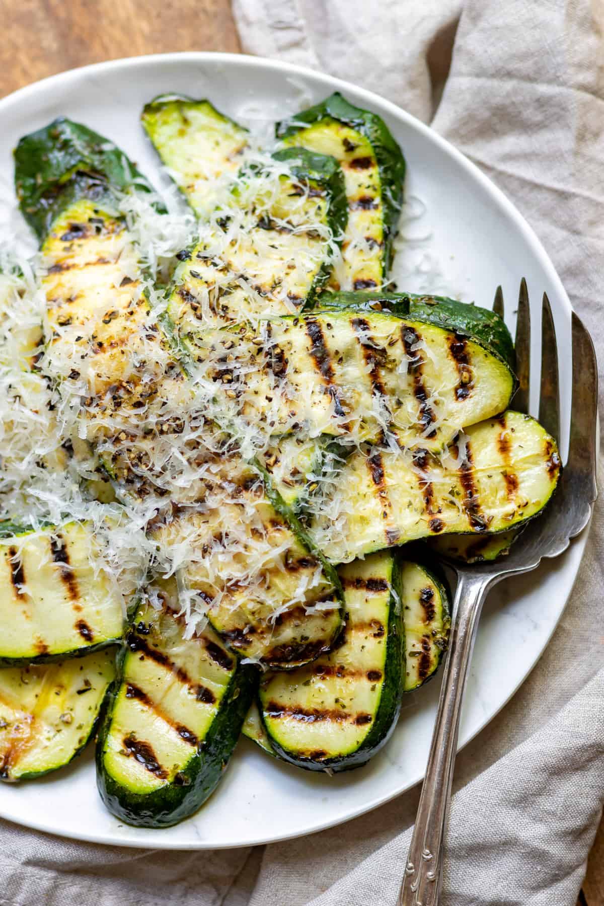 Serving dish of grilled zucchini topped with parmesan cheese.