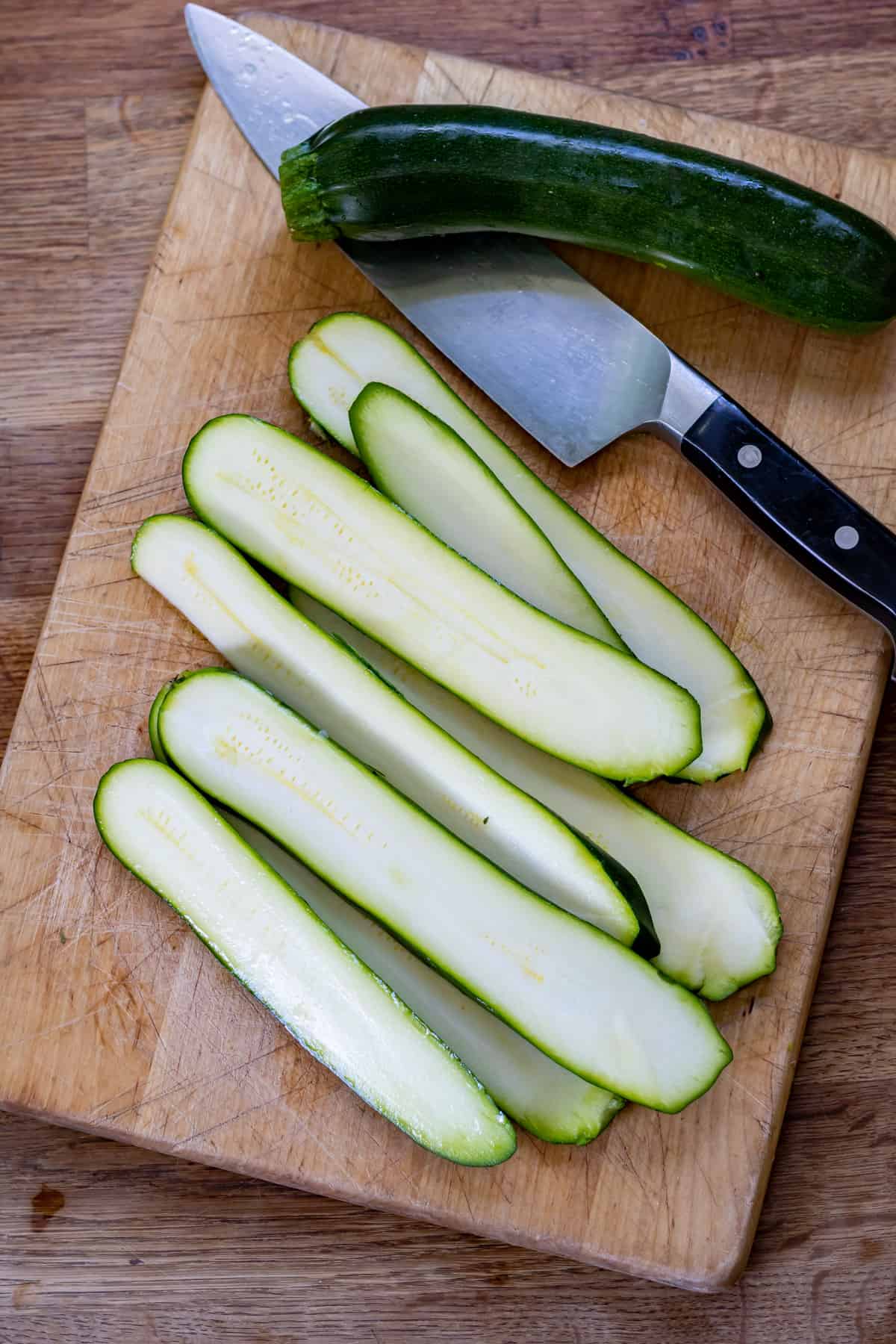 Slicing zucchini into long strips.