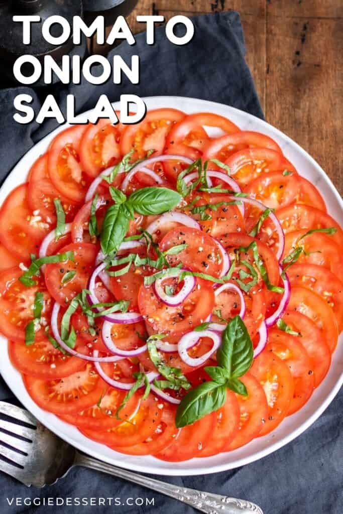 Salad on a plate on a wooden table, with text: Tomato Onion Salad.