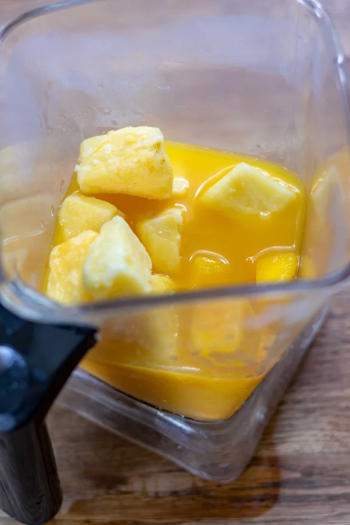 Mango, pineapple, orange juice and vanilla in a blender.