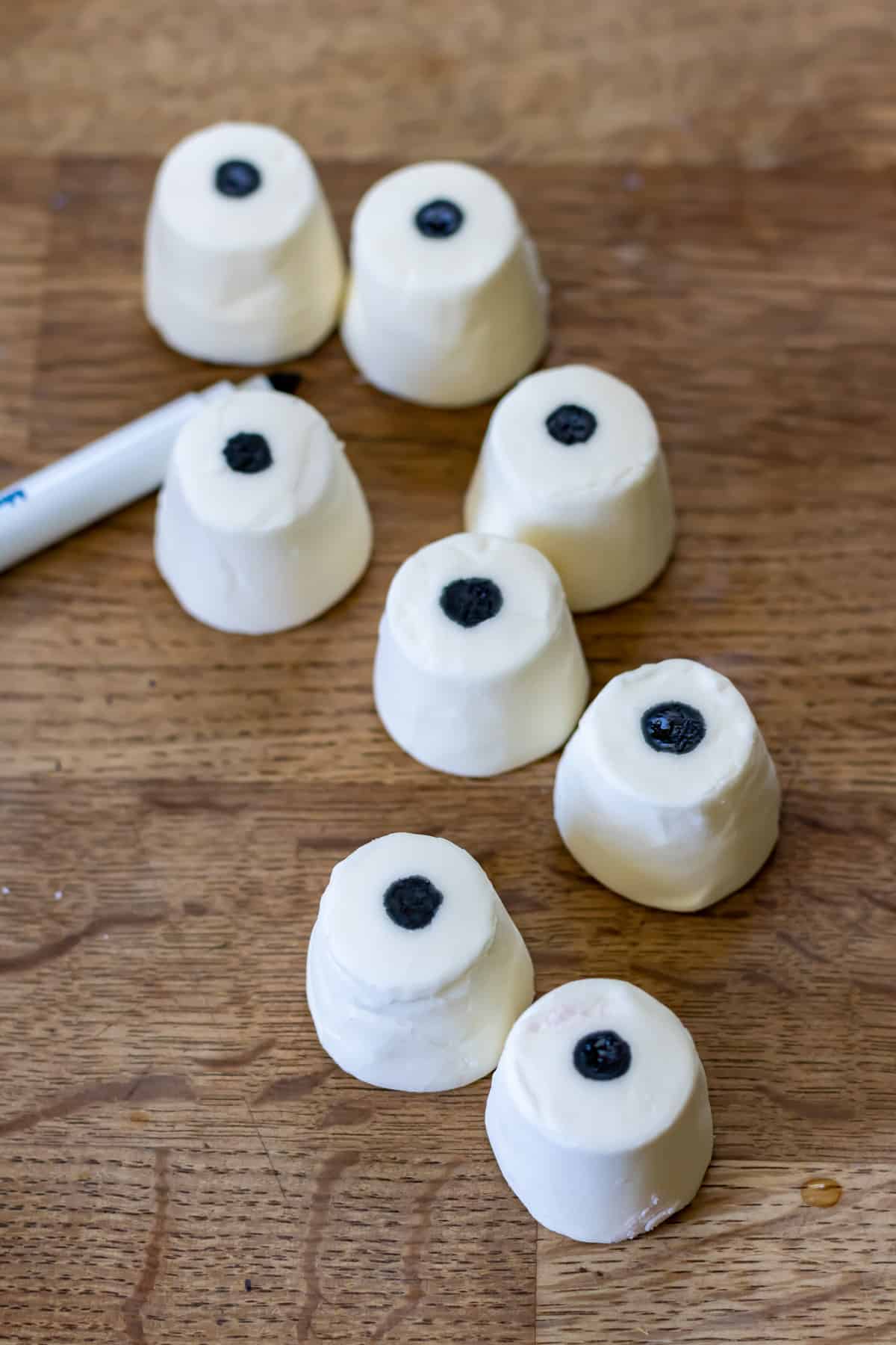 Making black circles on marshmallows to look like eyes.