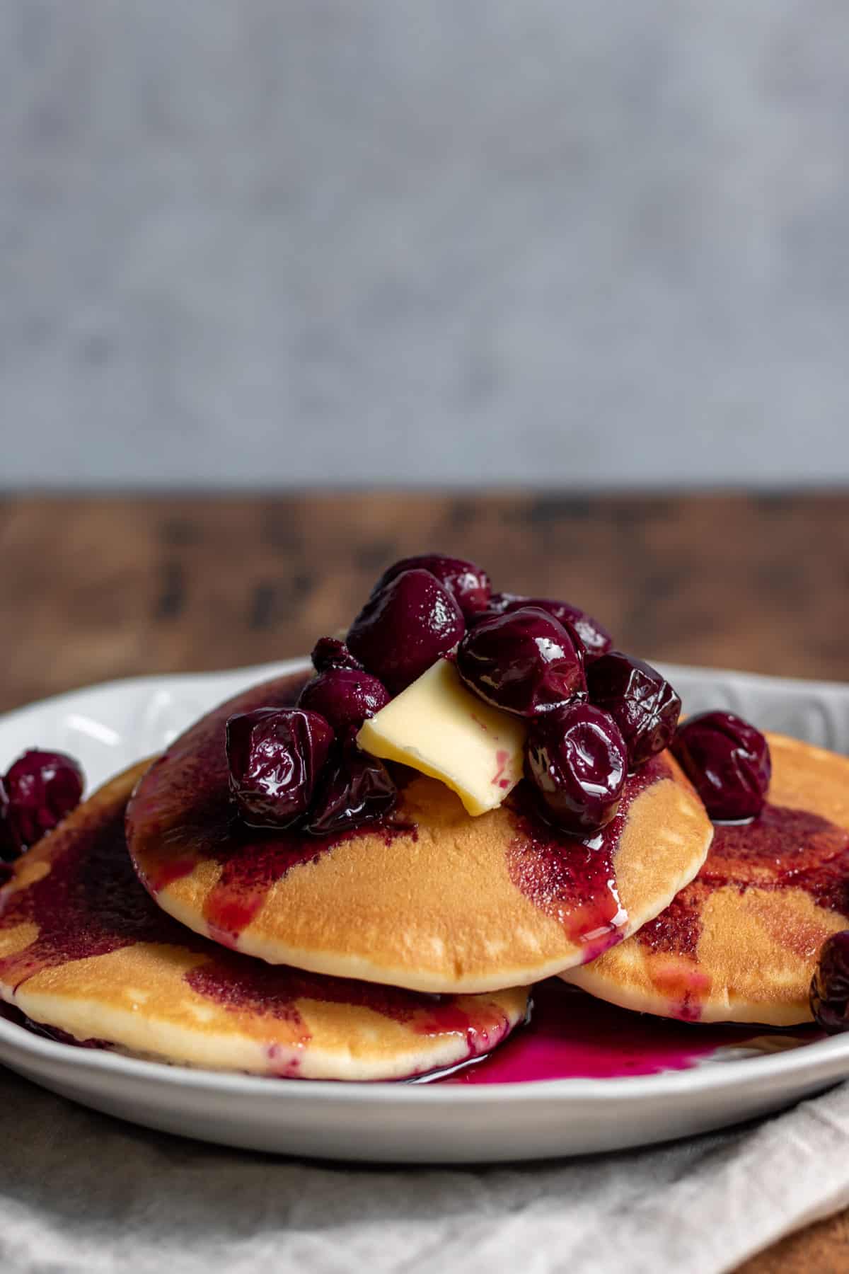 Pancakes on a plate topped with grape compote.