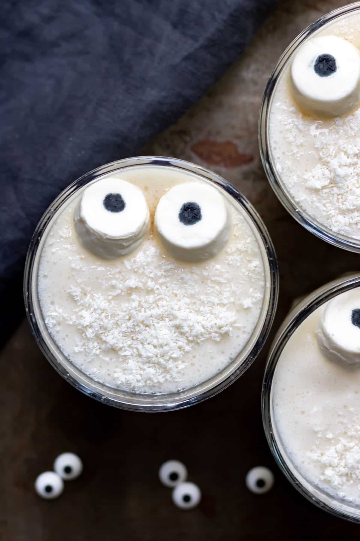 Glass of smoothie with marshmallow eyes.