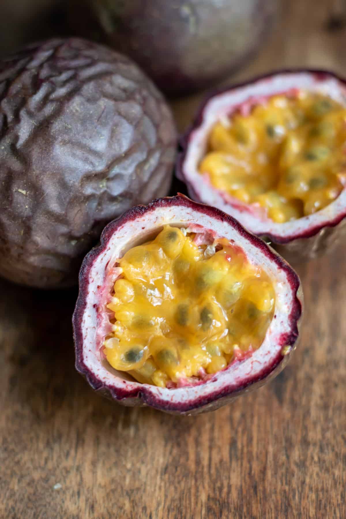 Cut open passion fruit on a table.