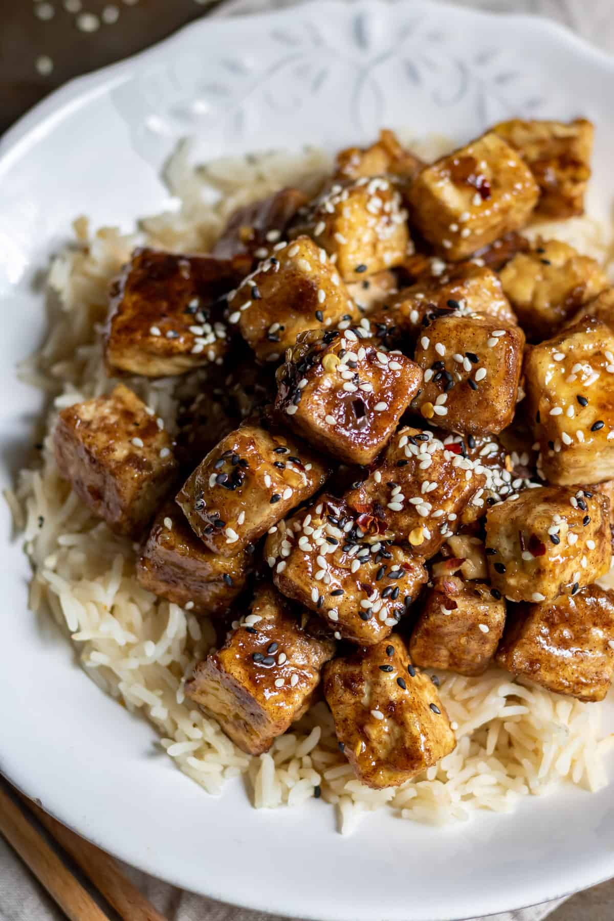 Looking down at a plate of tofu in sticky asian sauce.