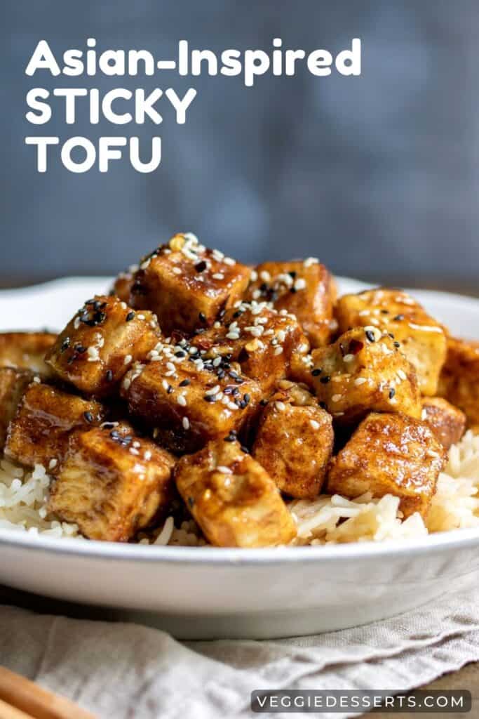 Close up of tofu on a plate, with text: Asian-inspired Sticky Tofu.