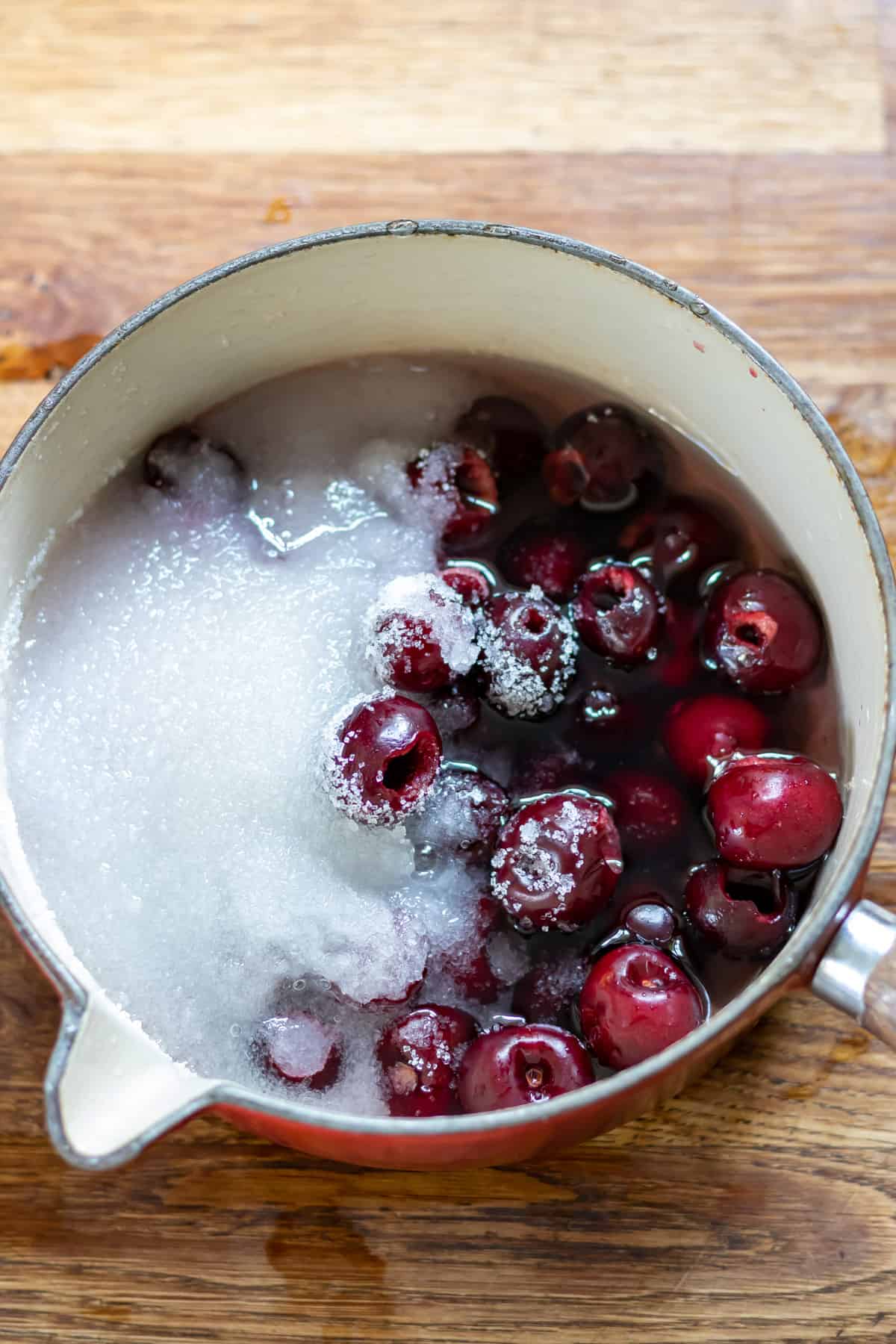 Cherries and sugar in a pot.