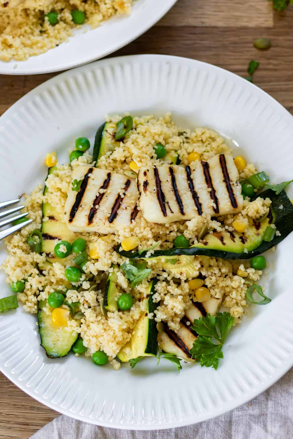 Close up of a plate of couscous with grilled halloumi and zucchini.