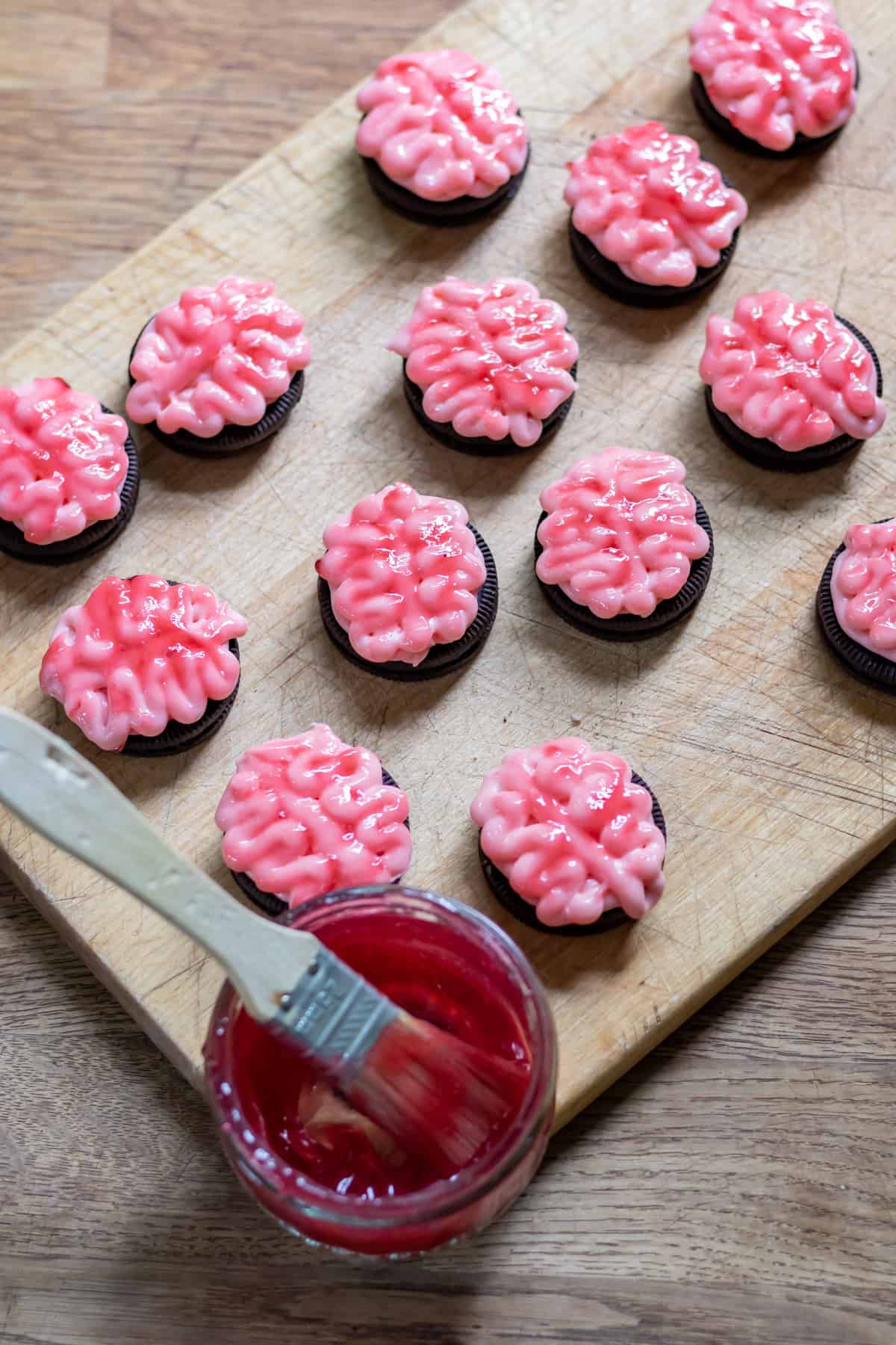 Brushing the 'brain' frosted cookies with jelly.