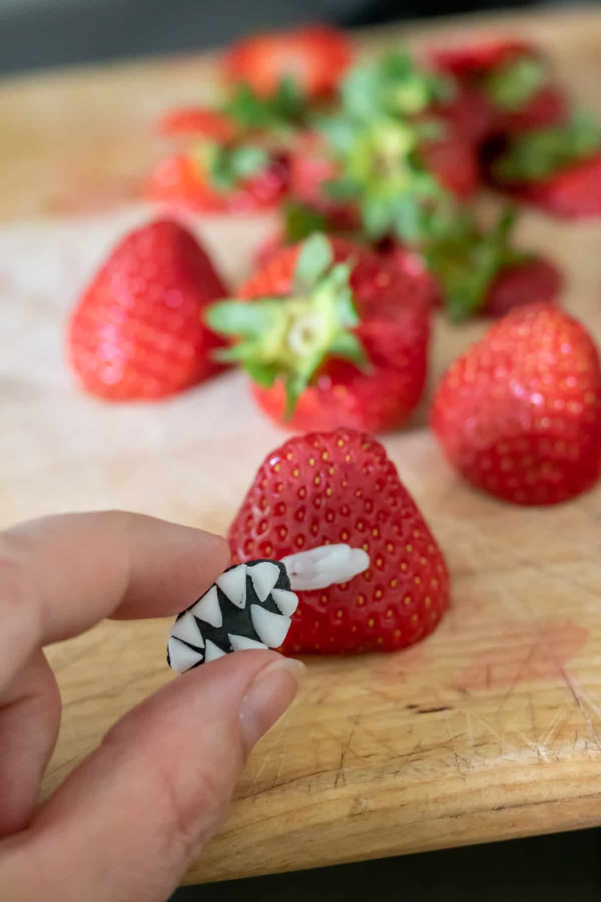 Adding fondant mouths to strawberries.