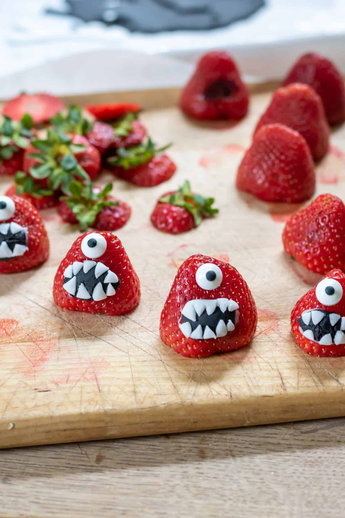 Decorating strawberries to look like monsters.