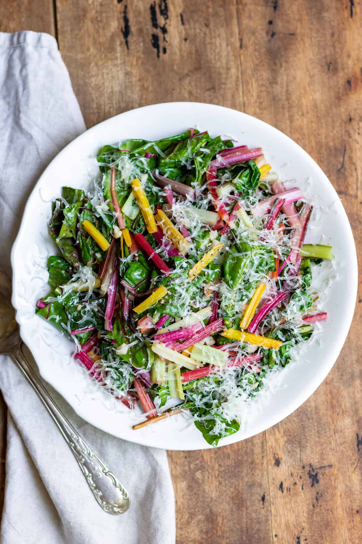 Table with a serving dish of sauteed rainbow chard.