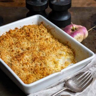 Baking dish of turnip casserole with a scoop out.