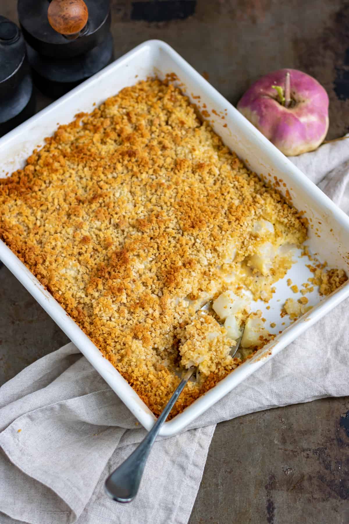 Baking dish of turnip casserole with a scoop out.