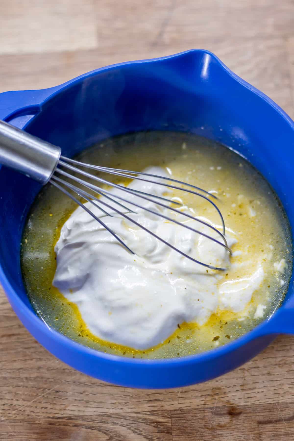 Whisking the sour cream into a small dish of soup.